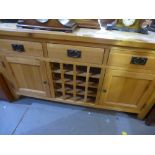 A modern oak sideboard with central wire rack