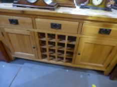 A modern oak sideboard with central wire rack