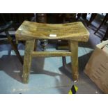 An old carved stool in splayed supports