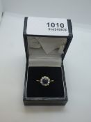 Yellow metal dress ring, possibly 18ct, cluster ring set with central sapphire, surrounded by 10