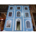 A three storey dolls house with blue and white furniture