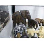 A shelf of carved elephant figures, mostly wood, etc