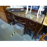 An Edwardian mahogany writing table having central bow drawer on square legs and a French style