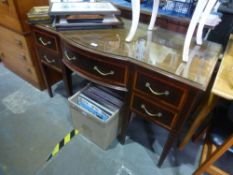 An Edwardian mahogany writing table having central bow drawer on square legs and a French style