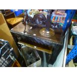 A dark stained oak side table on carved supports, along with a glass topped carved coffee table