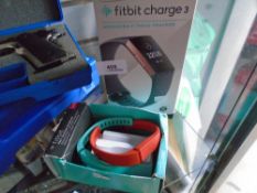 A boxed Rose Gold Fit Bit charge 3 and Fit Bit accessory wristbands