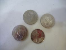 A selection of four coins, including a 1977 one dollar