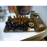 A wooden chess set and dominoes