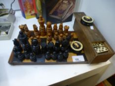 A wooden chess set and dominoes