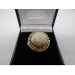 14 carat gold ring marked 585, containing large central Opal surrounded by smaller opalescent stones