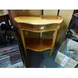 A bow fronted reproduction hall table having two drawers on tapered supports