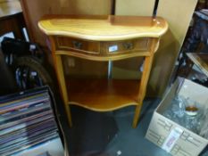 A bow fronted reproduction hall table having two drawers on tapered supports