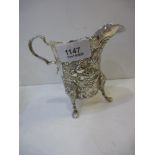 An Irish silver jug with ornate design and high quality. foliate and vine embossed design with three