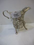 An Irish silver jug with ornate design and high quality. foliate and vine embossed design with three