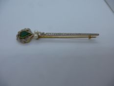 Art Deco style brooch with diamond cut emerald surrounded with diamonds, leading to two seed pearls,