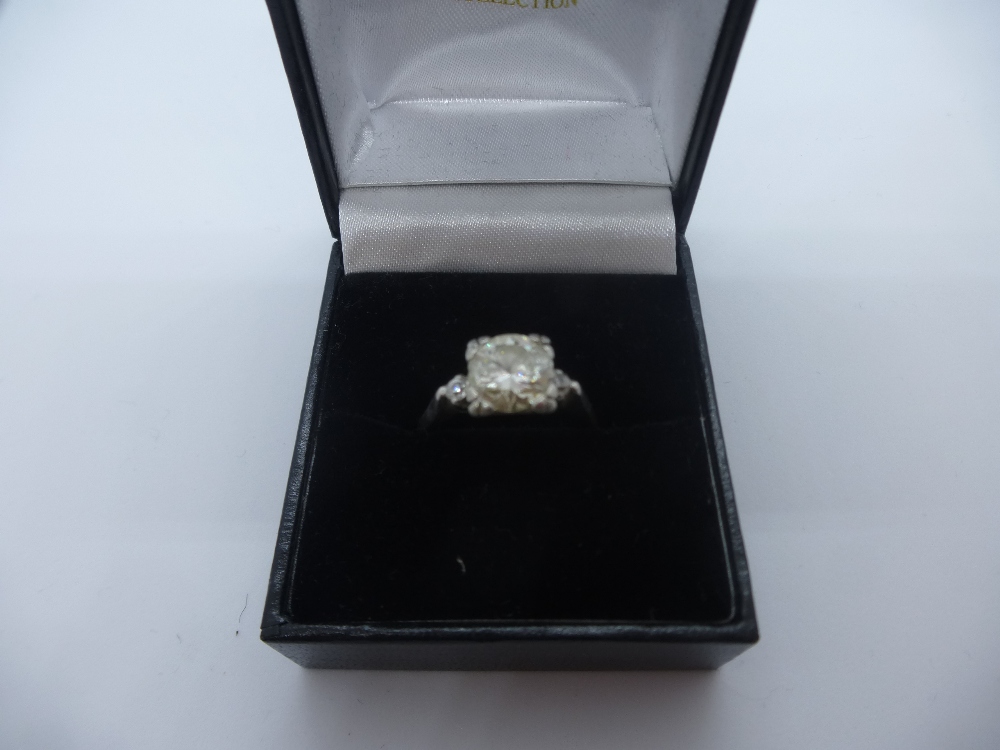 Platinum ring with central diamond, approx 1.75 CARAT, many inclusions, flanked by 2 smaller