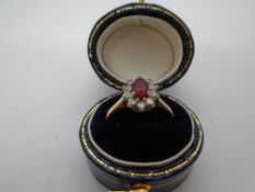 18ct yellow gold cluster ring with central ruby surrounded by small diamonds, marked 750, size L