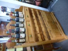 A modern pine kitchen cupboard having wine racks and two drawers