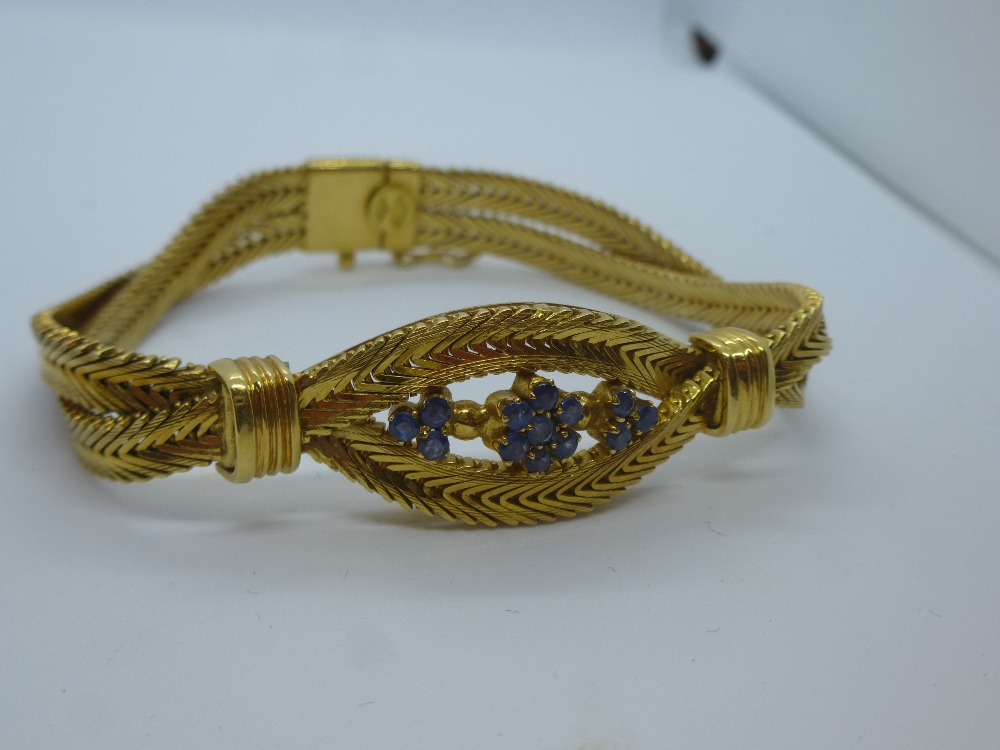 Pretty 18K yellow gold crossover bracelet with Sapphires set in a floral design, marked 750, total