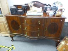 A 1920's mahogany sideboard having serpentine drawers with shaped back, width 152cms