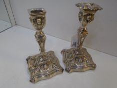 Pair of Sheffield silver table candlesticks decorated in the classical style, shaped square bases,