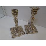 Pair of Sheffield silver table candlesticks decorated in the classical style, shaped square bases,