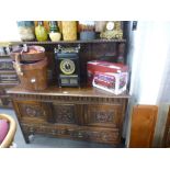 An antique carved oak sideboard having raised panel back on turned supports, 137cms