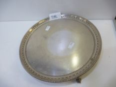 A silver tray with beaded rim, raised on three feet, decorative design hallmarked Sheffield 1933,