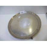 A silver tray with beaded rim, raised on three feet, decorative design hallmarked Sheffield 1933,