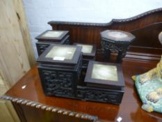 A pair of Chinese hardwood stands, having carved decorations and inset marble tops, and one