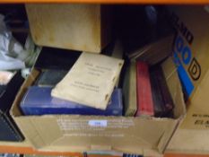A box of old books mostly comprising of vintage bibles and a display case
