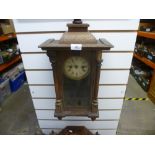 Two wooden cased pendulum clocks and two spelt figures