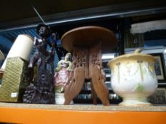 A brass magazine rack, small wooden carved table, wooden figures