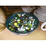 A blue bowl full of marbles, some vintage