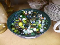 A blue bowl full of marbles, some vintage