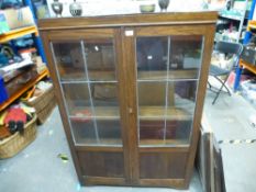 A dark stained oak bookcase with leaded glass doors