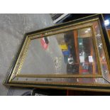 A rectangular wood framed bevelled mirror with a star design