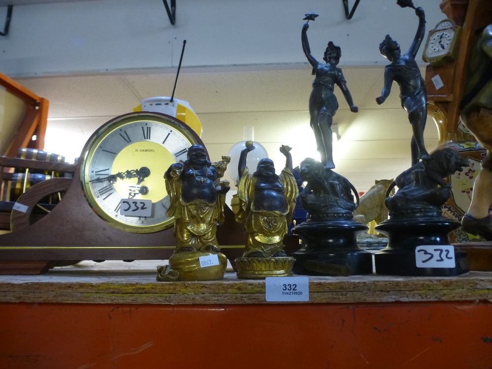 A mantle clock, two spelter figures of a man and lady and two Budhas