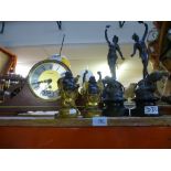 A mantle clock, two spelter figures of a man and lady and two Budhas