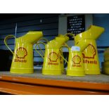 Five Shell oil cans