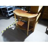 A bow fronted reproduction hall table having two drawers on tapered supports