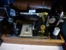 A cased Singer sewing machine and a cased vintage typewriter with ribbons, and a wooden walking
