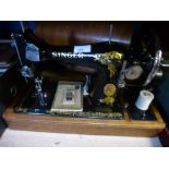 A cased Singer sewing machine and a cased vintage typewriter with ribbons, and a wooden walking