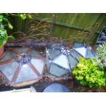 A set of three vintage metal and glass hexagonal lanterns with a set of three wrought iron corner