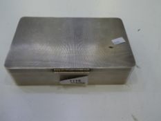 A heavy silver cigarette box having an engine turned design exterior and a gilted interior with