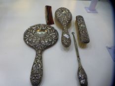 A silver dressing table set of five items of two brushes, comb, mirror and a silver handled button