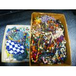 A tray of beadwork jewellery and a box of costume jewellery