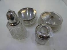 A silver lot comnprising of silver lidded dressing table set and a silver lidded sugar sifter with