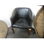 An old black leather desk chair on cabriole legs