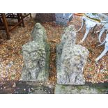 A pair of reconstituted stone pouncing lions, with ram's heads, on oblong base, 59 cms